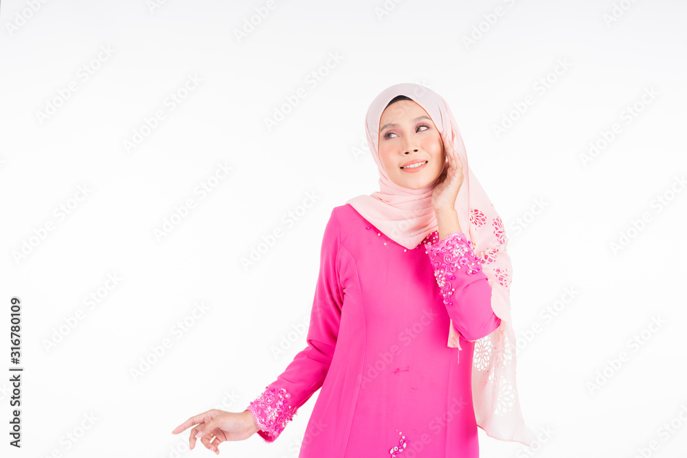 Beautiful female model wearing pink modern kurung, a modern urban lifestyle apparel for Muslim women isolated on white background. Beauty and hijab fashion concept.