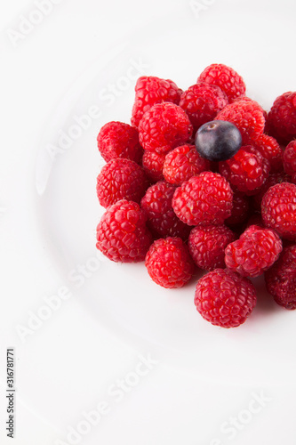 Blueberry over raspberries against white background