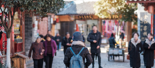 young woman traveler traveling at the Square street in Lijiang Old Town, landmark and popular spot for tourists attractions in Lijiang, Yunnan, China. Asia travel concept