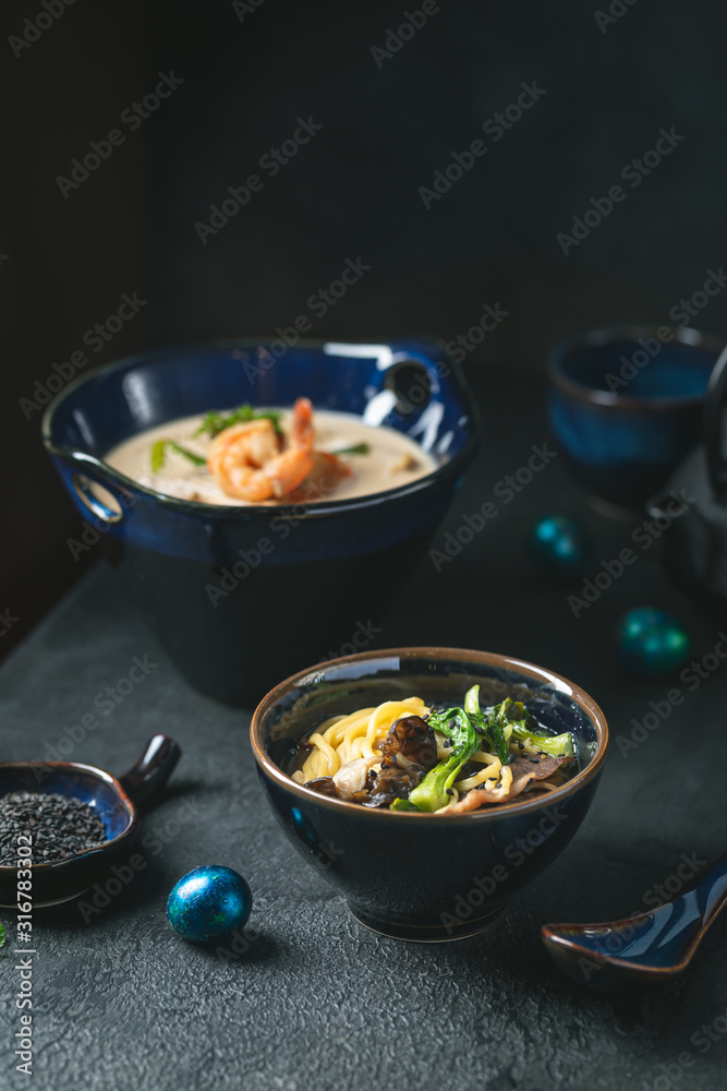 Asian ramen noodles soup with beef, oyster mushrooms and vegetables in bowl on dark background Asian ramen noodles soup with beef, oyster mushrooms and vegetables in bowl on dark background