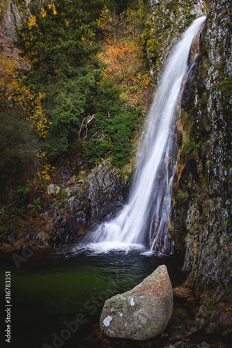 Natural waterfall in the middle of the mountains in autumn