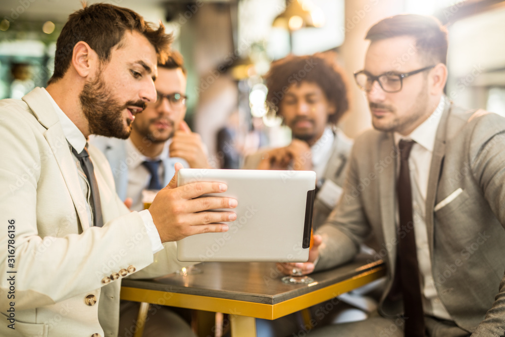 It's lucky to do the job you love. Four businessman siting in the cafe and they talk business It's lucky to do the job you love. Four businessman siting in the cafe and they talk business