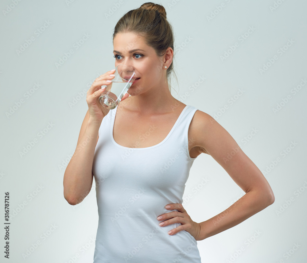 young woman in white sport vest drinking water from glass. young woman in white sport vest drinking water from glass.