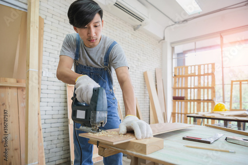 Close-up of a carpenter using a circular saw to cut a large board of wood