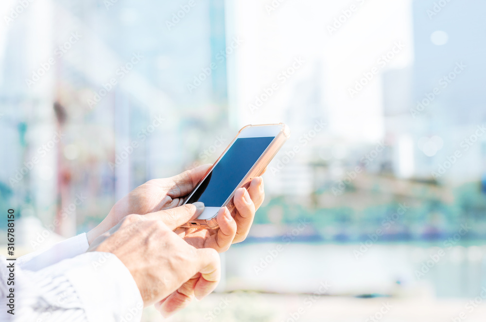 5G technology world wide web connecting.close up business man using hand typing smartphones and touch screen working search with app devices outdoor in city with sunrise and building background.
