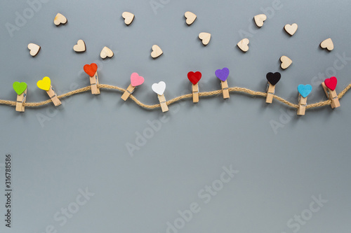 Clothespins in the form of hearts on a gray background with copy space