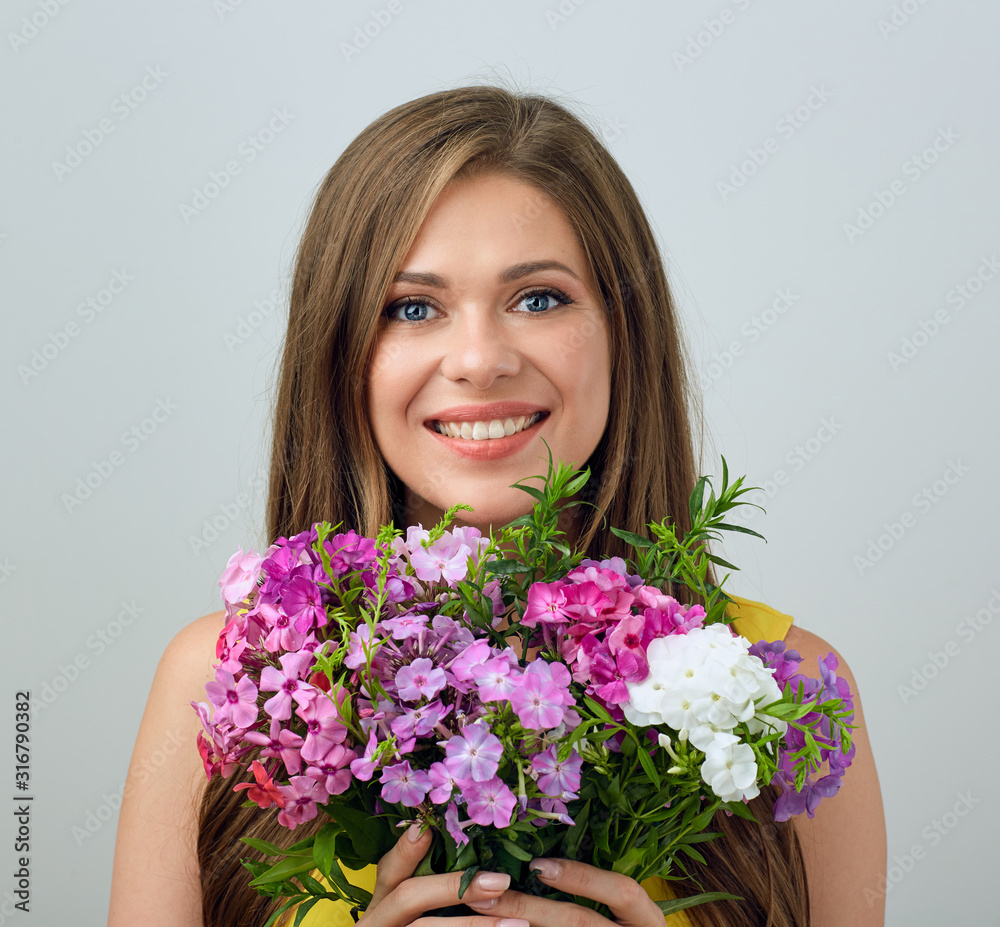 Smiling girl holding flovers in front of face. Smiling girl holding flovers in front of face.