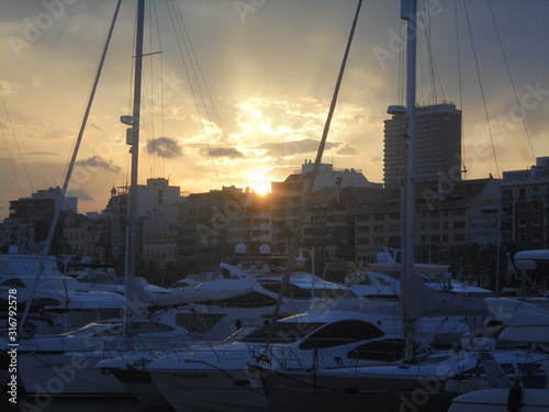 Tramonto dietro barche bianche
