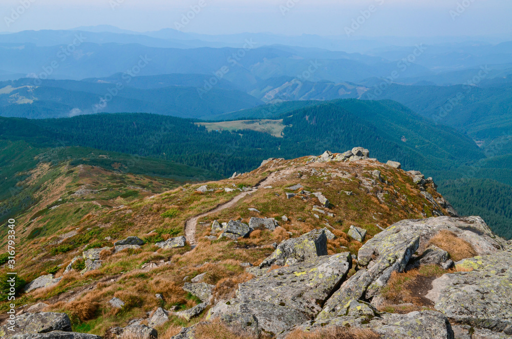 Tourist hiking route along the high ridge between the peaks of the Carpathian Mountains