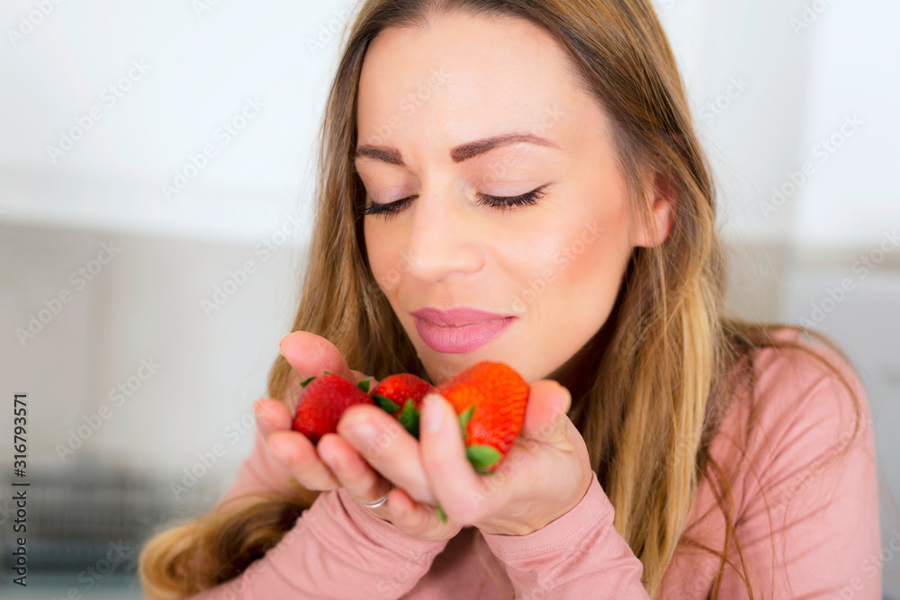 Beautiful girl smelling fresh strawberries Beautiful girl smelling fresh strawberries
