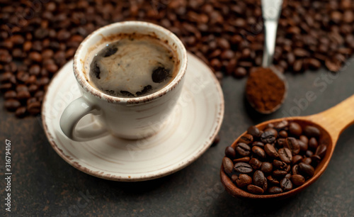 Cup of tasty coffee and beans on a stone background. Top view with copy space for your text.
