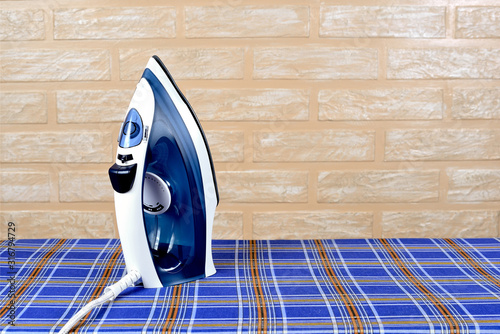 New modern electric steam iron on ironing board photo