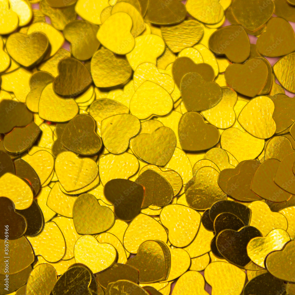 many golden hearts strewn white background