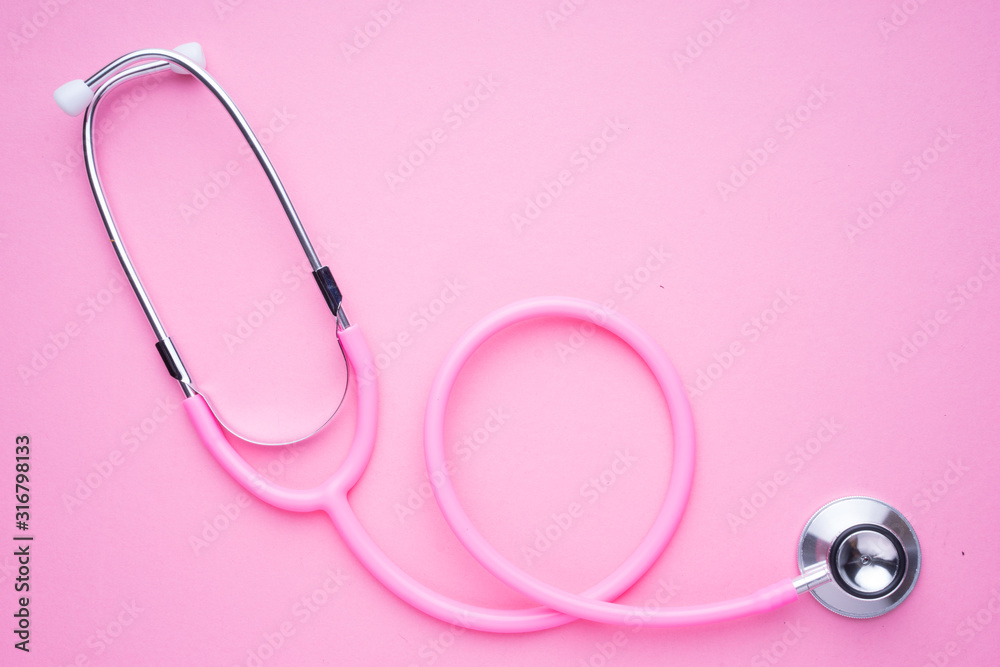 Fototapeta premium Women in the healthcare industy concept. A pink strethoscope on a pink background.