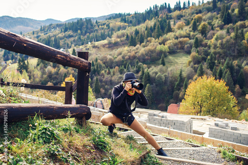 beautiful woman photographs nature on the mountain in autumn.