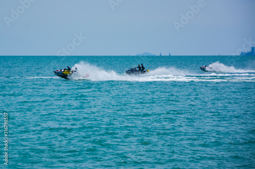 group of tourists sailing on jet skis off the coast Near Pattaya in Thailand,group of jet ski park at the beach on the morning at Larn island,Chonburi,Thailand
