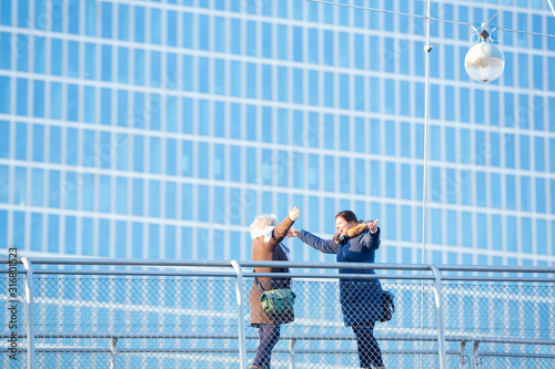 Konstfotografi Business women find each other at pedestrian bridge