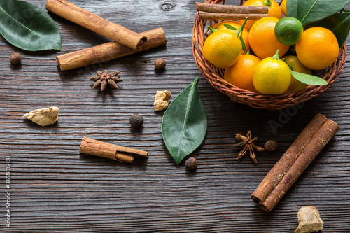 still life with calamondines in basket, cinnamon sticks, anise star, cardamom, ginger. side view. photo