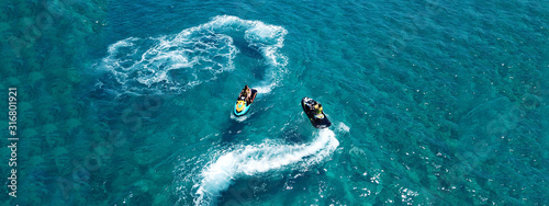 Aerial drone ultra wide photo of jet ski watercraft couple cruising in high speed in tropical exotic bay with turquoise sea © aerial-drone