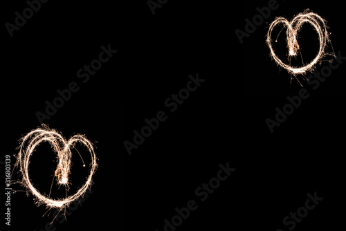 two love hearts on black background, light painting with a sparkler