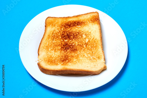 Toasted toast on a plate on a blue background.
