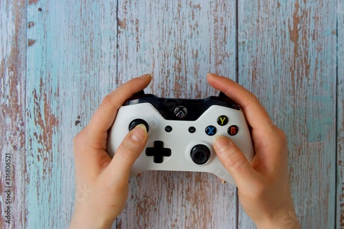 White gamepad to play with the Xbox that holds women's hands photo