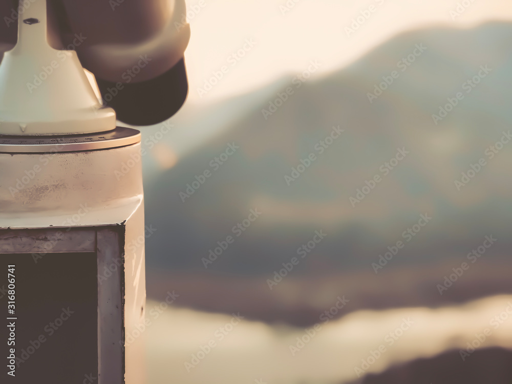 Paid outdoor tourist telescope against the backdrop of extending mountains and a river Paid outdoor tourist telescope against the backdrop of extending mountains and a river