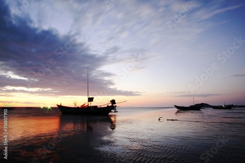 Old fishing boat at sunset and blurred clouds.