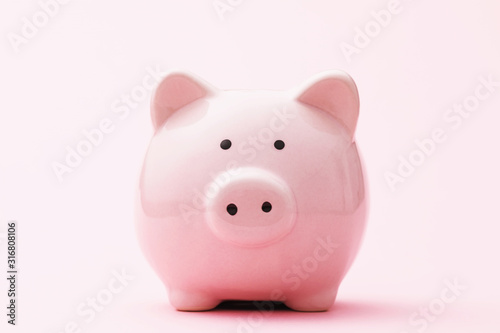Piggy bank on a pink background, front view