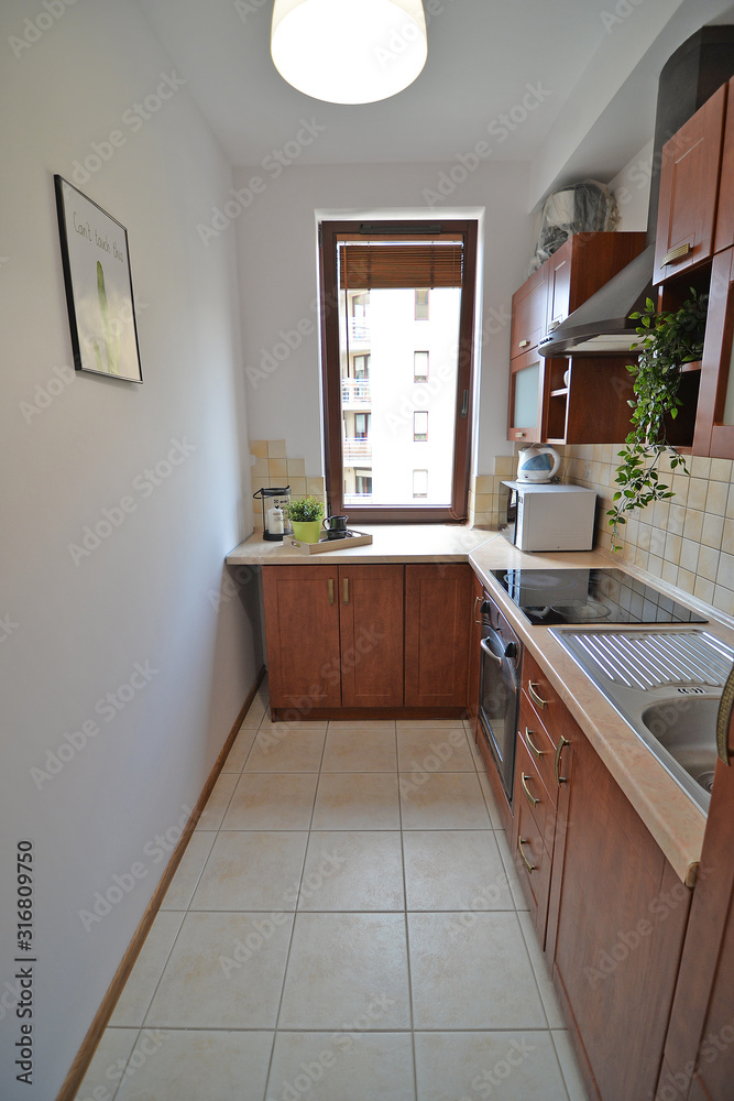 A home kitchen with a long countertop and a window.