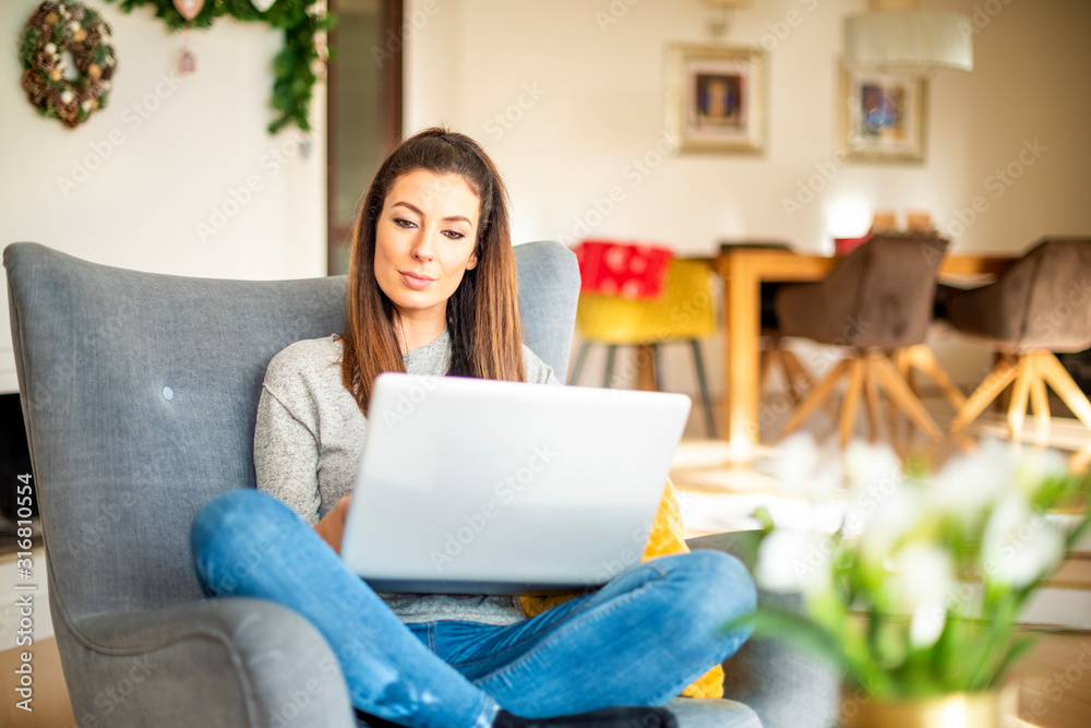 Casual businesswoman using laptop while working online from home Casual businesswoman using laptop while working online from home
