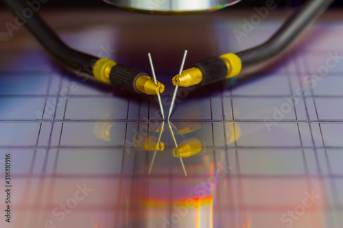 Close up of examining a sample of microchip transistor with probe station under the microscope in laboratory.A semiconductor on a silicon wafer. Selective focus. photo