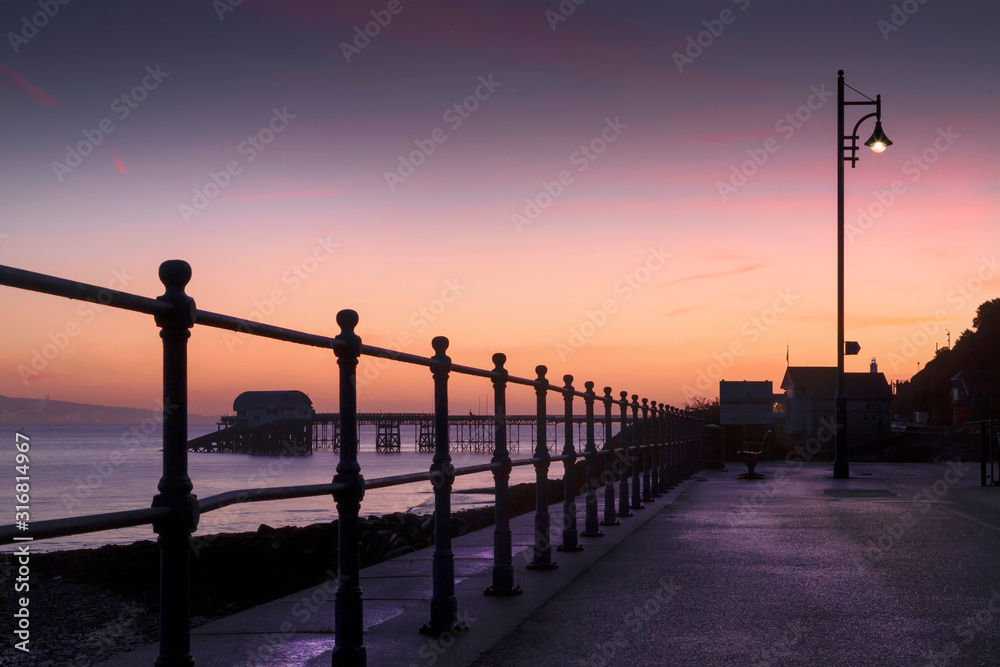 Dawn by lamp light at the prom and Mumbles pier in Swansea, South Wales, UK