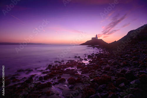 A Winter sunrise over the Mumbles lighthouse and the South Gower headland, Swansea, UK