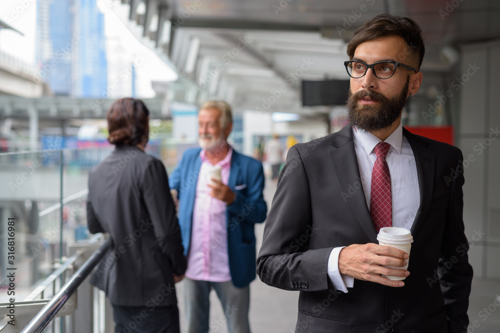 Three multi ethnic bearded businessmen together around the city Three multi ethnic bearded businessmen together around the city