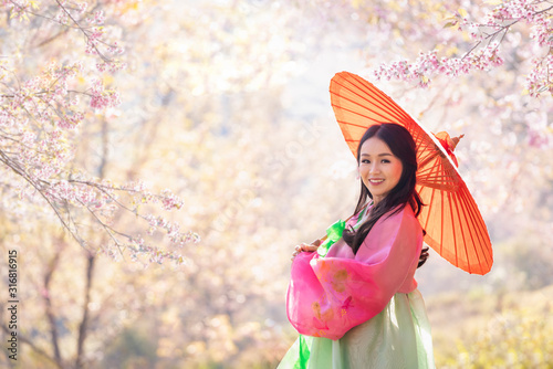 Photography Korean girl wearing a hanbok wearing a red umbrella