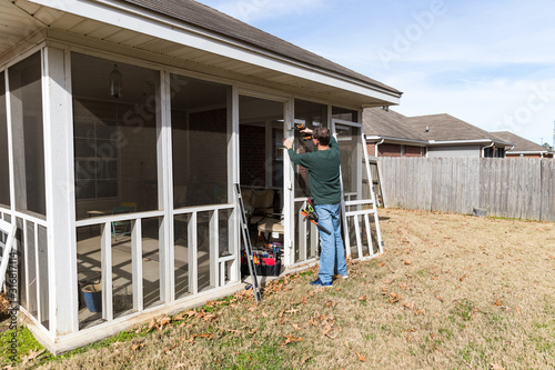 Cuadro en lienzo Homeowner works on repairing door to screened in back porch