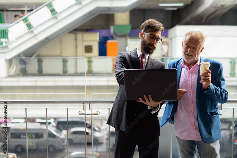 Two multi ethnic bearded businessmen together around the city Two multi ethnic bearded businessmen together around the city
