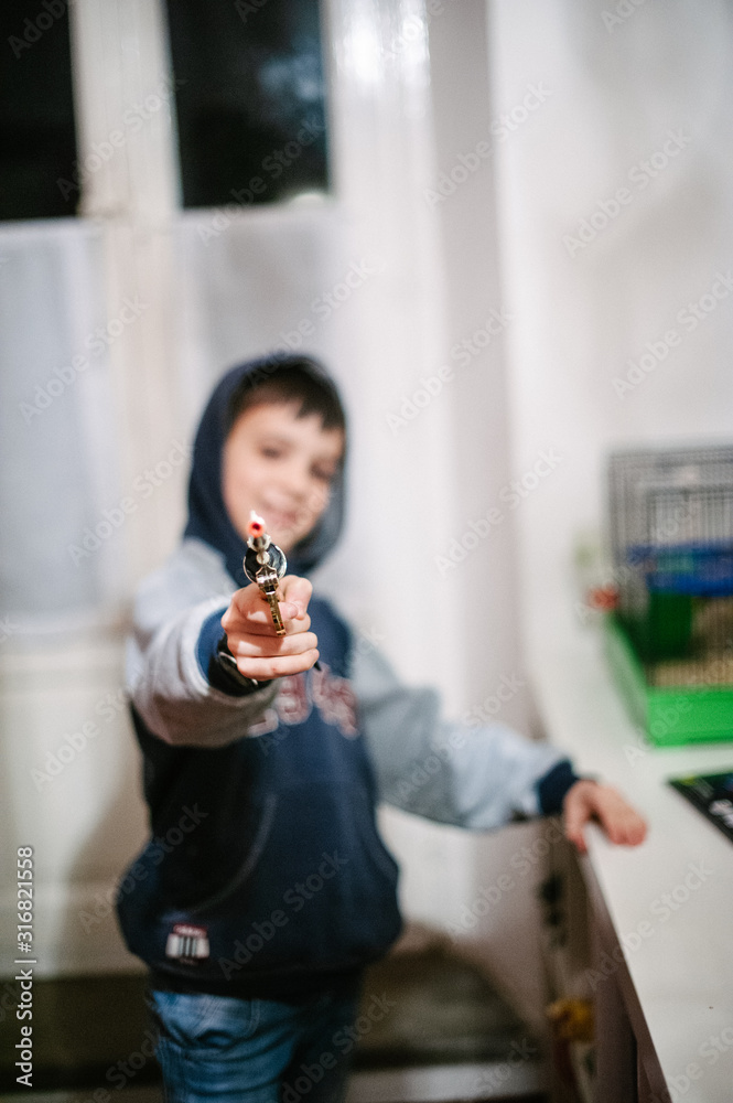 child with toy gun shoots against camera lens child with toy gun shoots against camera lens