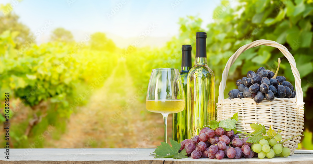 Colorful grapes in basket, white wine