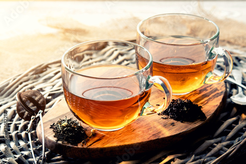 two cups of black tea on a wicker table early in the morning, closeup. Tea morning at dawn.