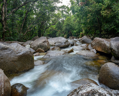 Josephine Falls and Fast Flowing Stream in rainforest at Wooroonooran National Park near Cairns, Queensland Australia.