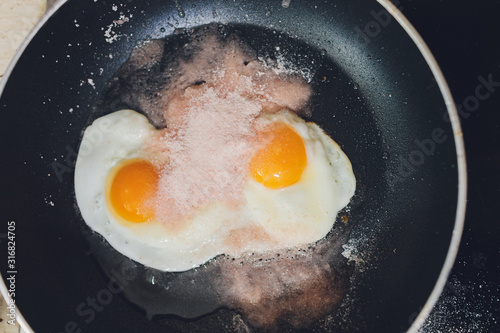 Appetizing photograph of scrambled eggs from one chicken egg in a pan with boiling sunflower oil. photo