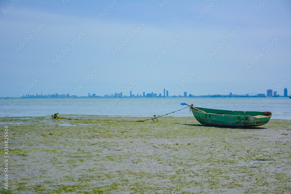 Fishing boat parked on the beach,Fishing boat parked on the seashore,Small fishing boat parked and moored on the beach at low tide. Boat and anchor at the beach in summer vacation. Sunny day. Fishing boat parked on the beach,Fishing boat parked on the seashore,Small fishing boat parked and moored on the beach at low tide. Boat and anchor at the beach in summer vacation. Sunny day.