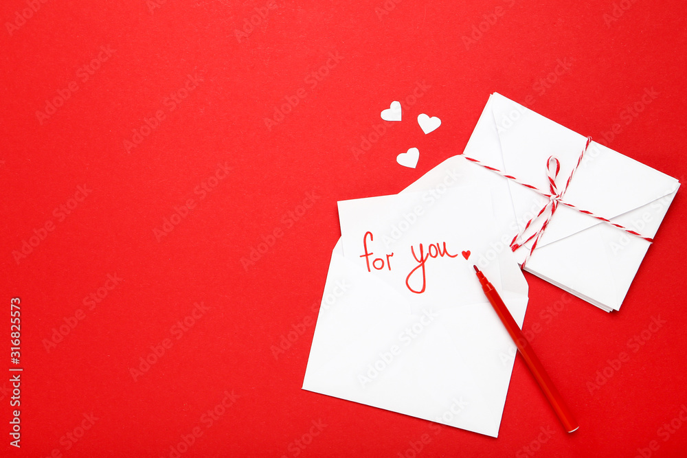 Paper envelopes with hearts and text For You on red background Paper envelopes with hearts and text For You on red background