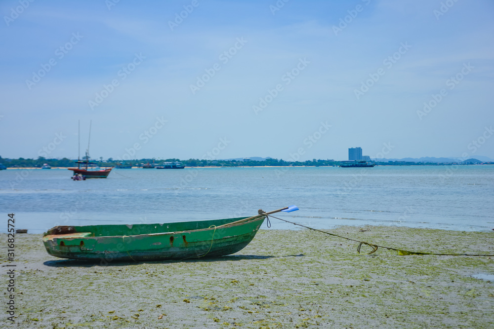 Fishing boat parked on the beach,Fishing boat parked on the seashore,Small fishing boat parked and moored on the beach at low tide. Boat and anchor at the beach in summer vacation. Sunny day. Fishing boat parked on the beach,Fishing boat parked on the seashore,Small fishing boat parked and moored on the beach at low tide. Boat and anchor at the beach in summer vacation. Sunny day.