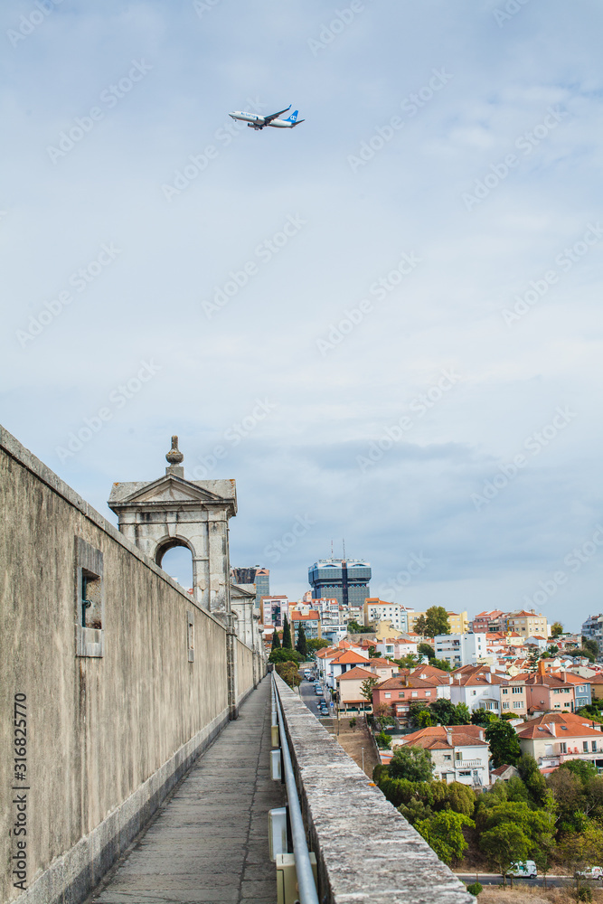 view from the aqueduct on the city with an aircraft in Lisbon