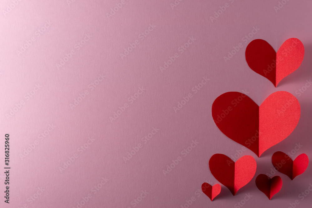 red hearts on pink background. Valentine's Day greeting. Top view. Space for text
