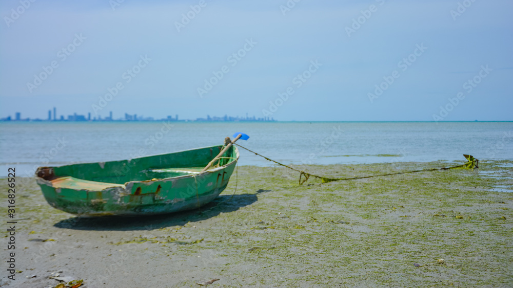 Fishing boat parked on the beach,Fishing boat parked on the seashore,Small fishing boat parked and moored on the beach at low tide. Boat and anchor at the beach in summer vacation. Sunny day. Fishing boat parked on the beach,Fishing boat parked on the seashore,Small fishing boat parked and moored on the beach at low tide. Boat and anchor at the beach in summer vacation. Sunny day.