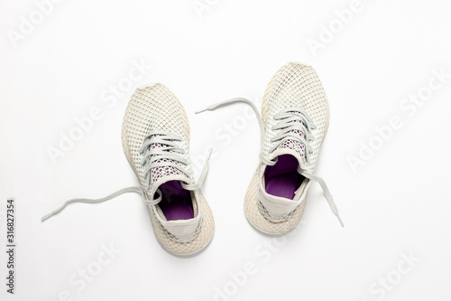Light white sneakers for running on a light background. Concept of running, workout, sport. Banner. Flat lay, top view